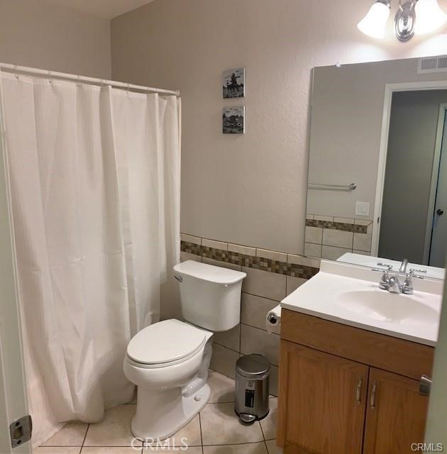 21897 Shenandoah Drive Lake Forest, CA 92630 - Photo 7 of 12 a bathroom with a sink a toilet a mirror and shower curtain