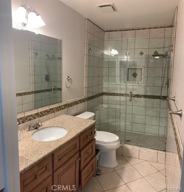 21897 Shenandoah Drive Lake Forest, CA 92630 - Photo 8 of 12 a bathroom with a granite countertop sink a toilet and shower