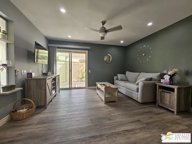 a living room with furniture and a wooden floor