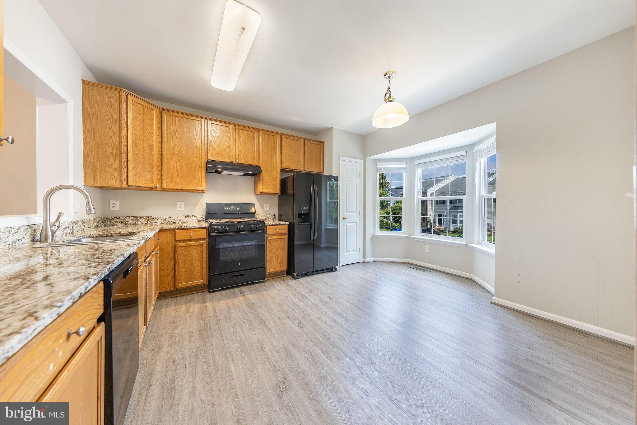 43115 Candlewick Square Leesburg, VA 20176 - Photo 9 of 31 a kitchen with granite countertop a stove a sink dishwasher a refrigerator cabinets and wooden floor