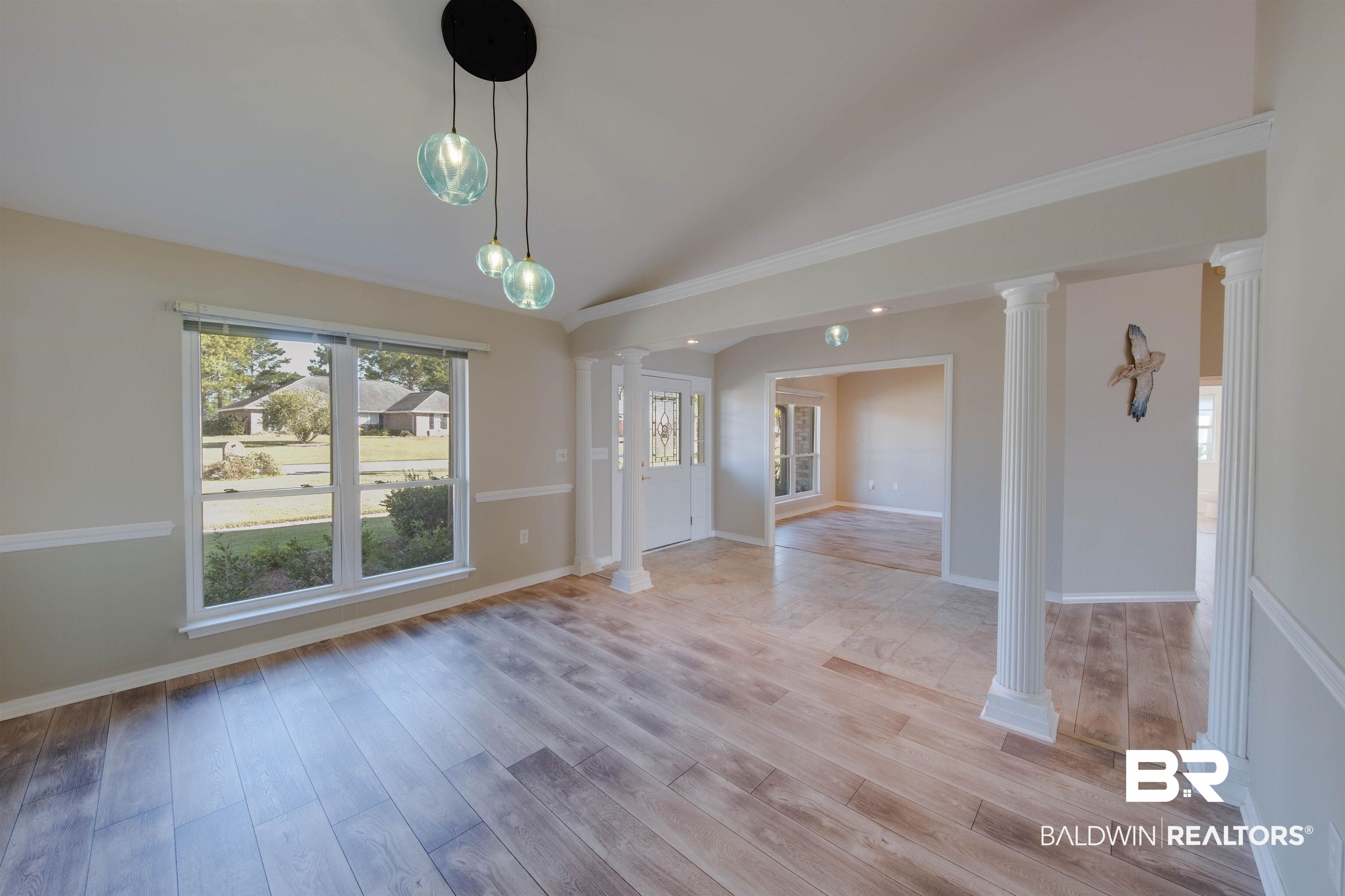 9462 Lakeview Drive Foley, AL 36535 - Photo 8 of 50 Unfurnished dining area featuring ornate columns, vaulted ceiling, and light hardwood / wood-style flooring