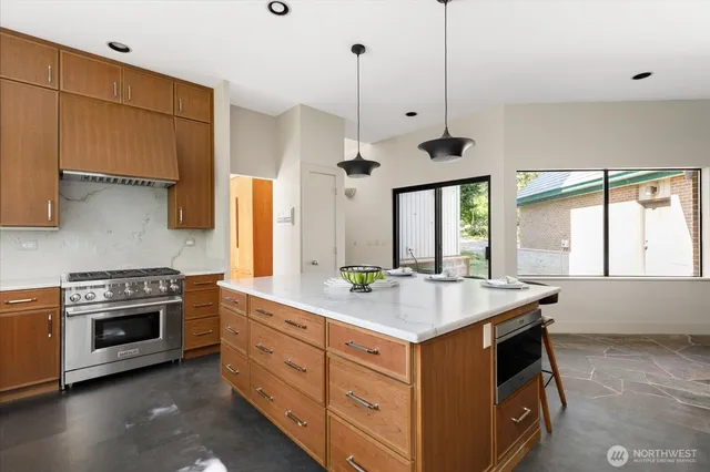 a kitchen with a stove a sink and a window