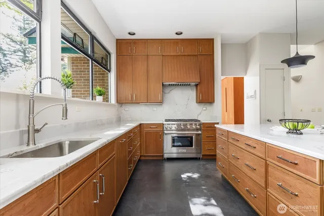 a kitchen with stainless steel appliances granite countertop a sink stove and cabinets