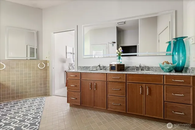 a spacious bathroom with a granite countertop sink and a mirror