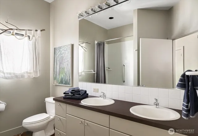 a bathroom with a granite countertop sink toilet a mirror and shower