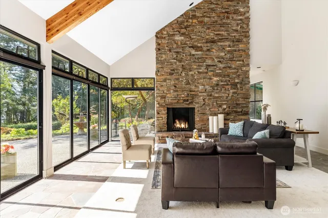 a living room with furniture a fireplace and a floor to ceiling window