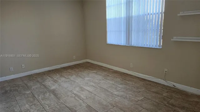 an empty room with wooden floor and cabinet