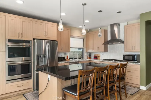 a kitchen with stainless steel appliances granite countertop a stove a refrigerator a oven a sink a table and chairs