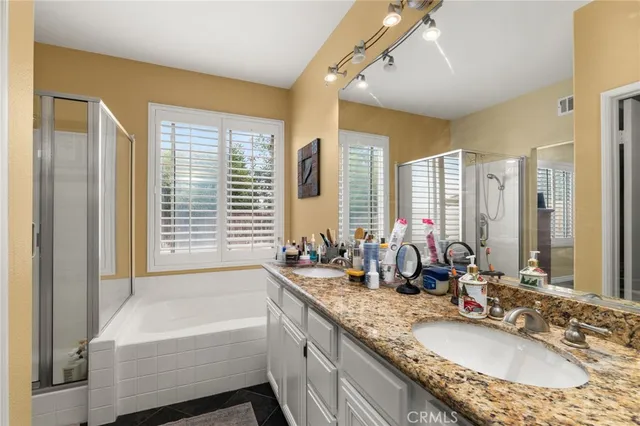 a bathroom with a granite countertop tub sink and mirror