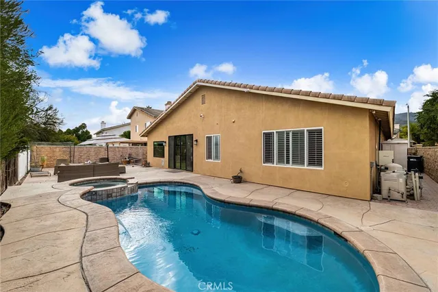 a house view with a swimming pool and sitting space