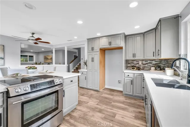 a kitchen with stainless steel appliances granite countertop a stove a sink and a refrigerator