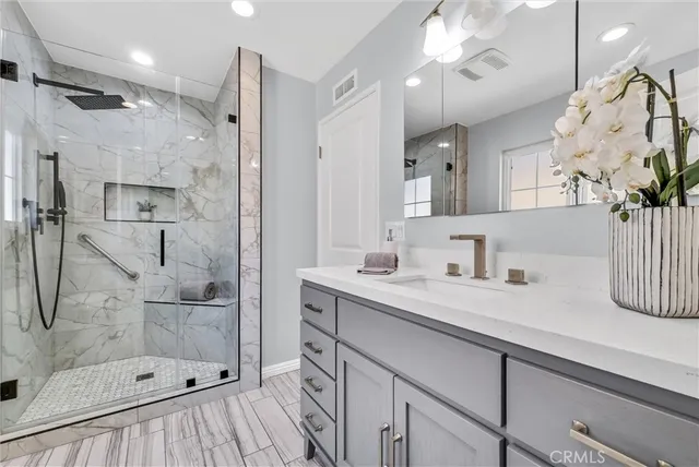 a bathroom with a sink a shower and a mirror