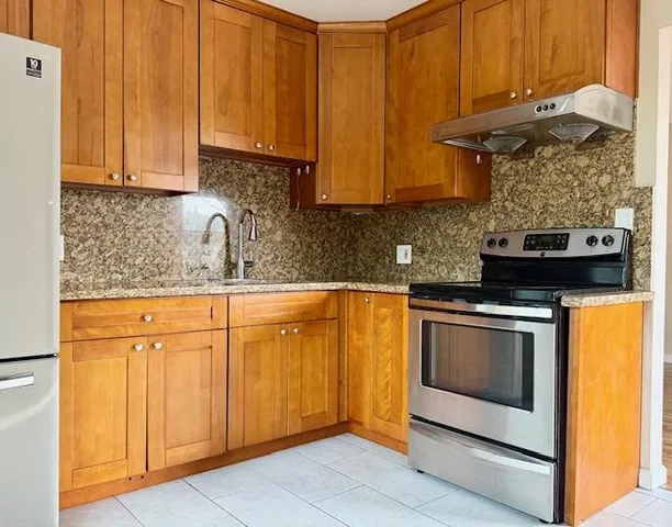 a kitchen with stainless steel appliances granite countertop a stove a sink and a microwave