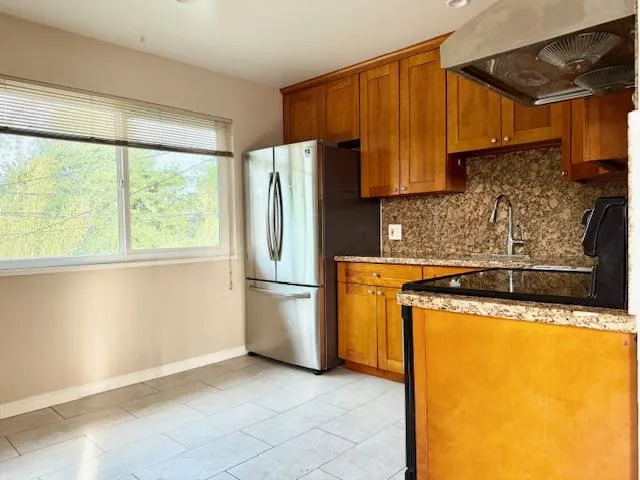 a kitchen with granite countertop a refrigerator a stove a washer and dryer