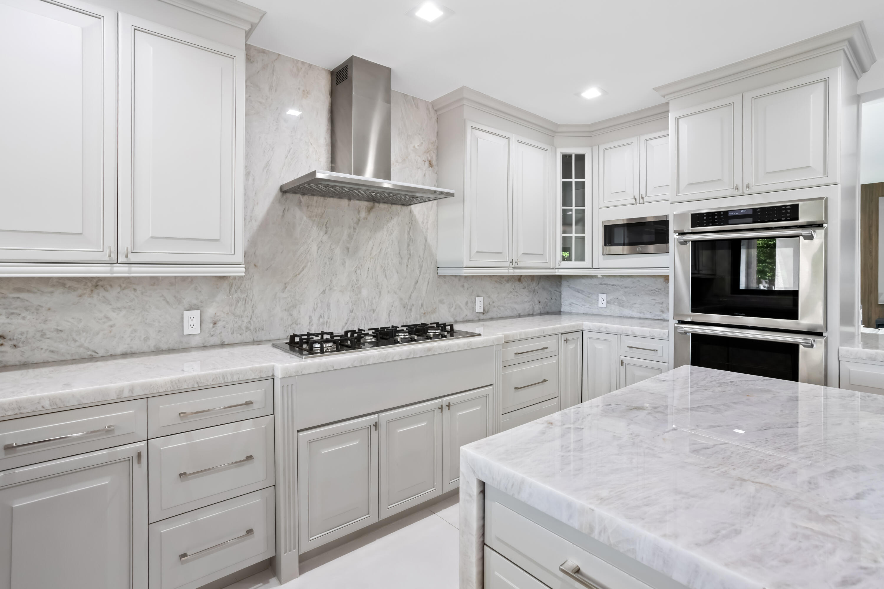 18743 Long Lake Drive Boca Raton, FL 33496 - Photo 20 of 84 a kitchen with white cabinets and stainless steel appliances
