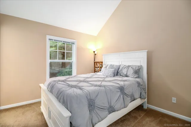 a bed sitting in a bedroom next to a window