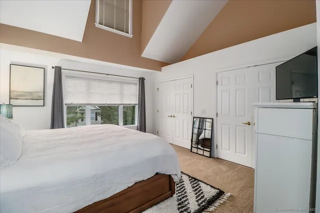 a bedroom with a bed closet and flat tv screen