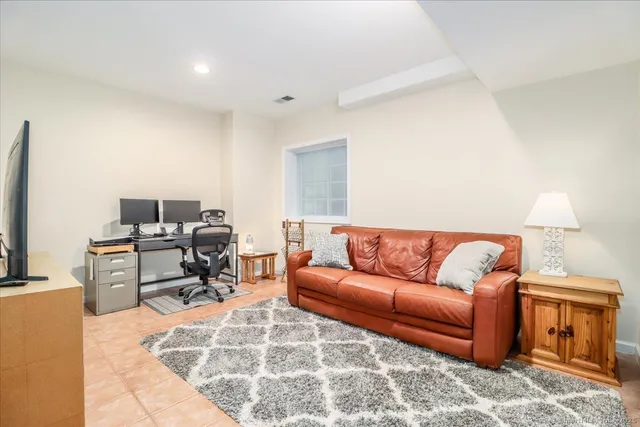 a living room with furniture a flat screen tv and a window