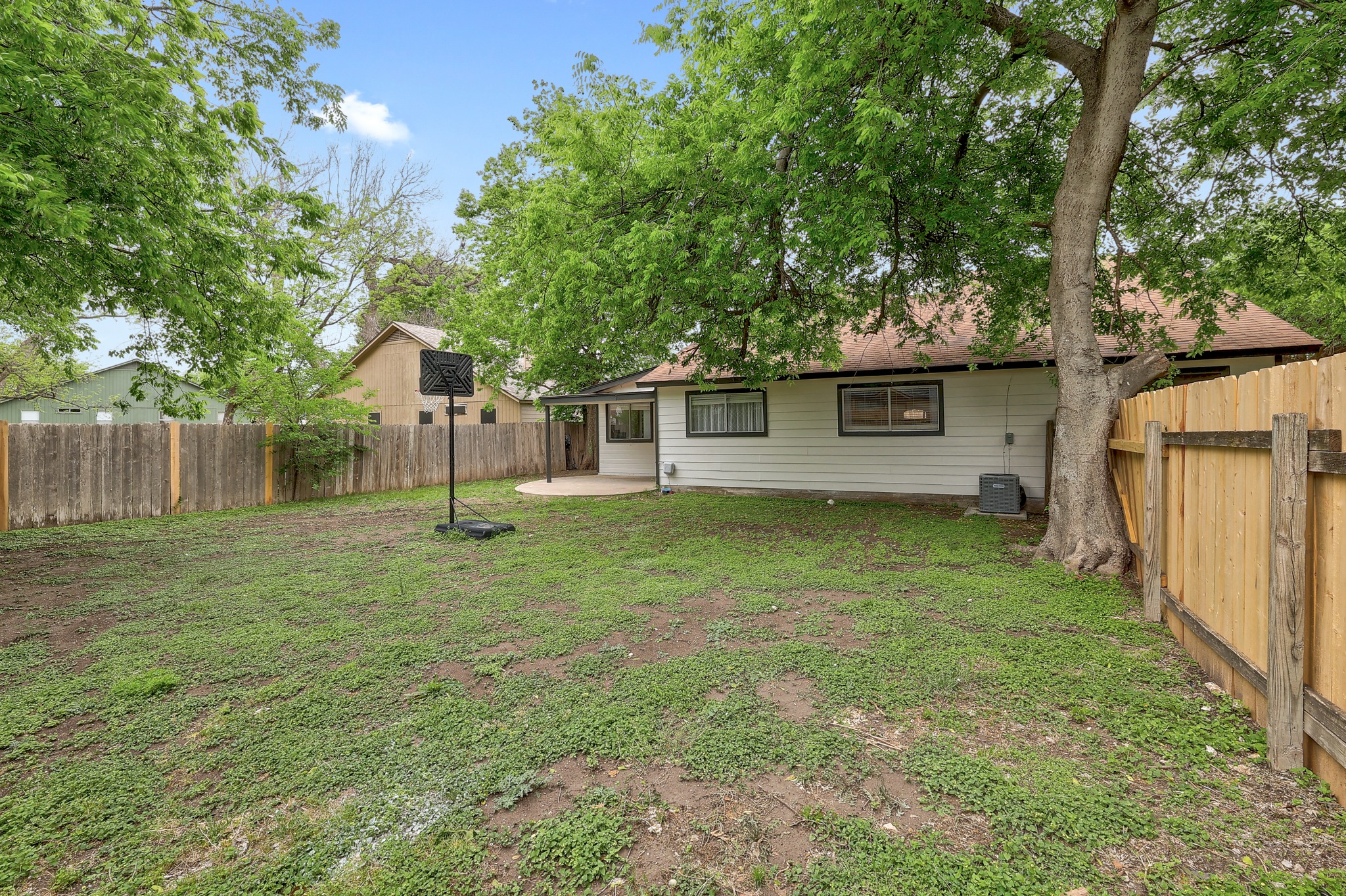 9901 Parliament House Road Austin, TX 78729 - Photo 36 of 40 Rear view of house with a patio, a fenced backyard, and a sunroom