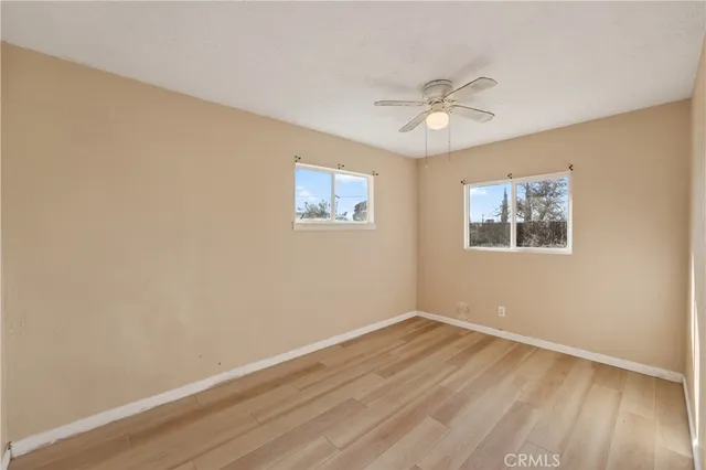 a view of a room with wooden floor and a ceiling fan