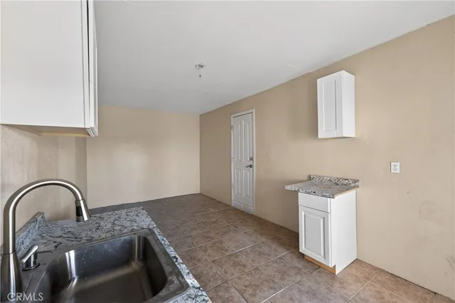 a kitchen with granite countertop a sink and a stove top oven