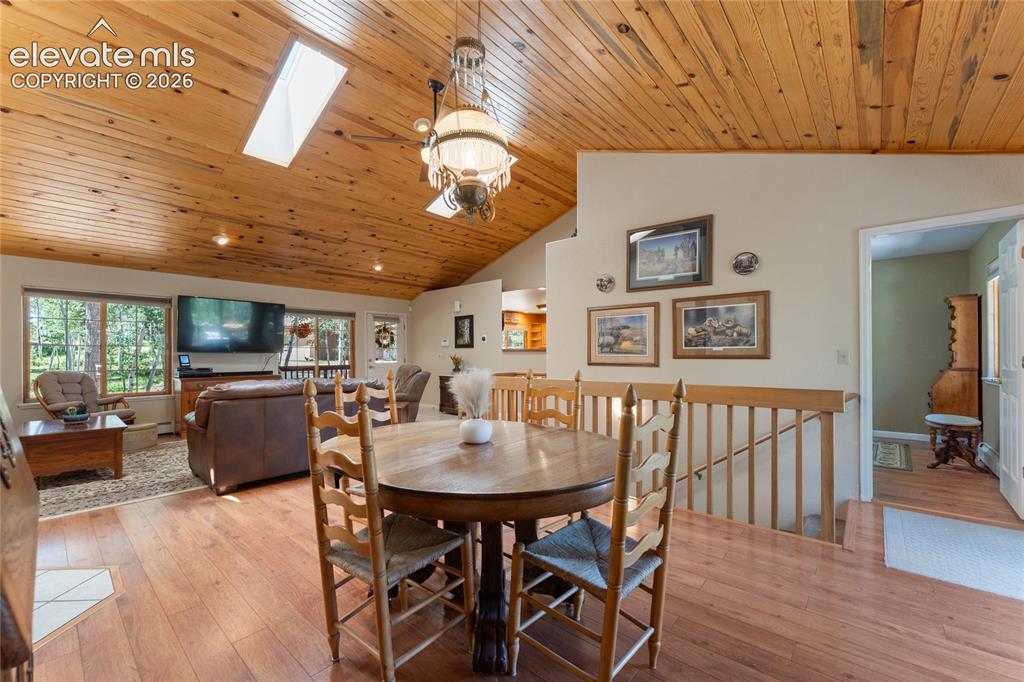 657 Spring Valley Drive Divide, CO 80814 - Photo 9 of 43 Vaulted wood-paneled ceilings with skylights, wood-finish flooring, and a decorative chandelier