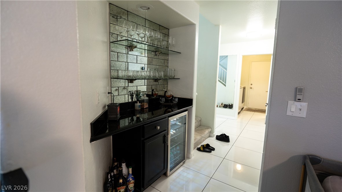 6429 Winding Ridge Las Vegas, NV 89156 - Photo 9 of 16 A sleek wet bar with glass shelving offers an elegant entertaining space.