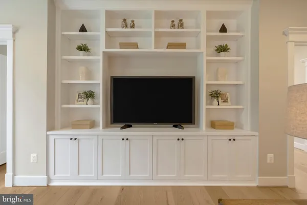a view of an empty room with a window and a kitchen