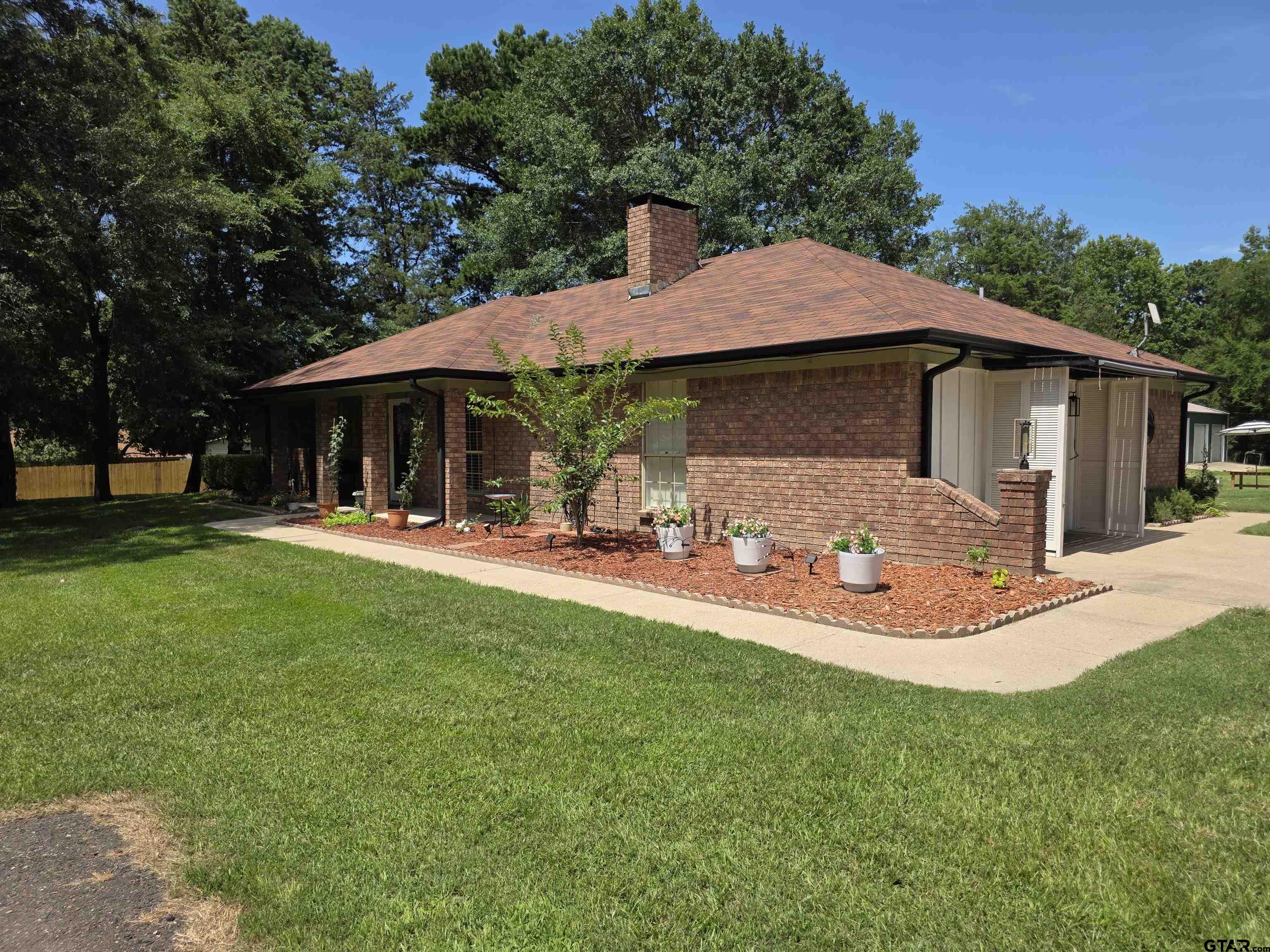 6170 Highway 271 Mount Pleasant, TX 75455 - Photo 2 of 43 a front view of a house with garden and trees