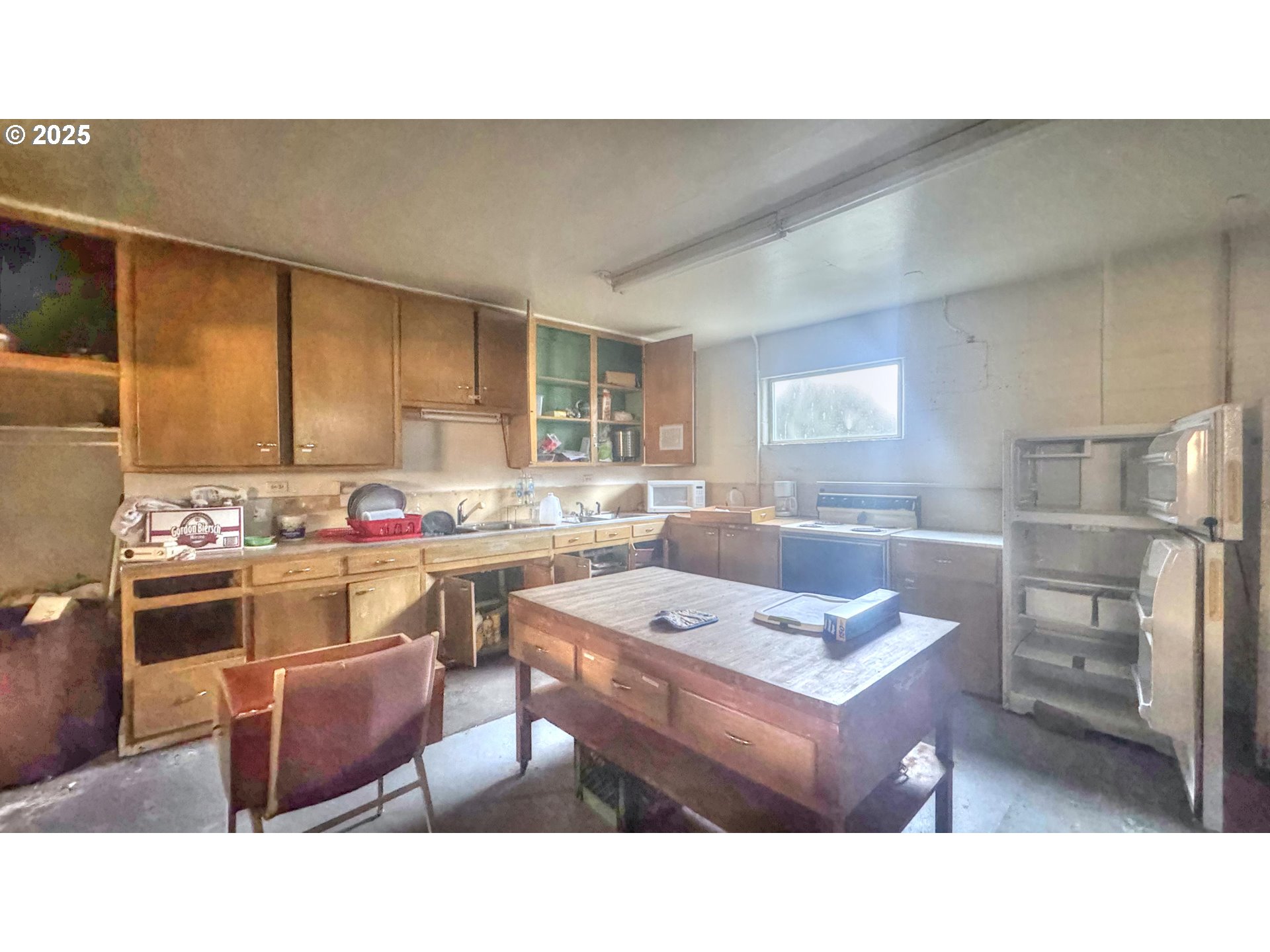 33043 Nesika Road Gold Beach, OR 97444 - Photo 17 of 23 a kitchen with kitchen island a sink table and chairs