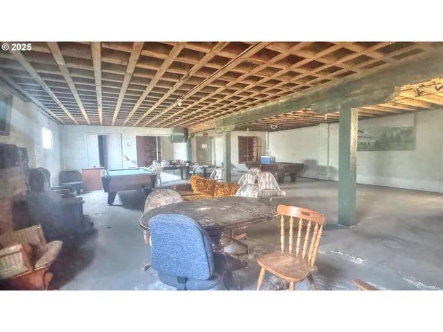 a room with lots of tables a large window and chairs