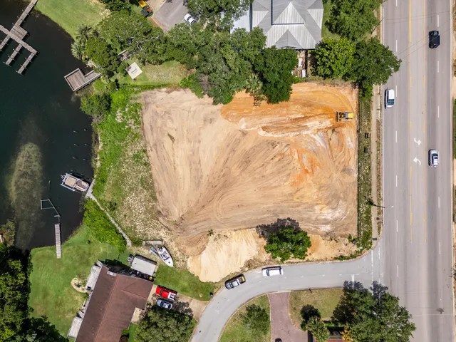 an aerial view of a house with a yard and lake view