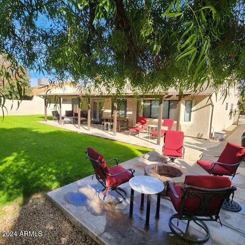 a view of a chairs and table in backyard of the house