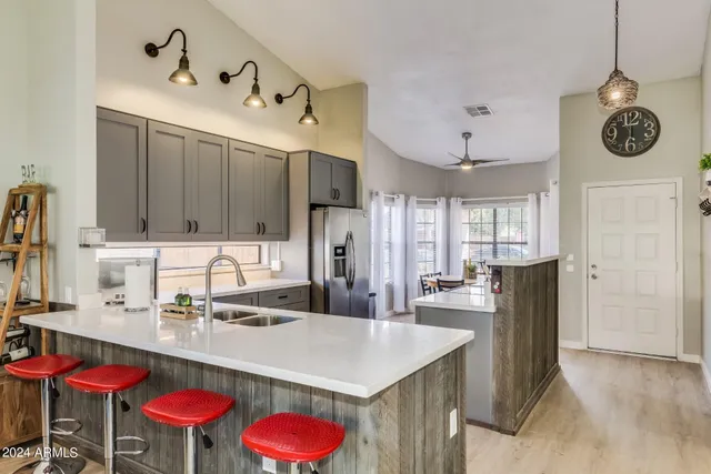 a kitchen with stainless steel appliances kitchen island granite countertop a table chairs and a refrigerator
