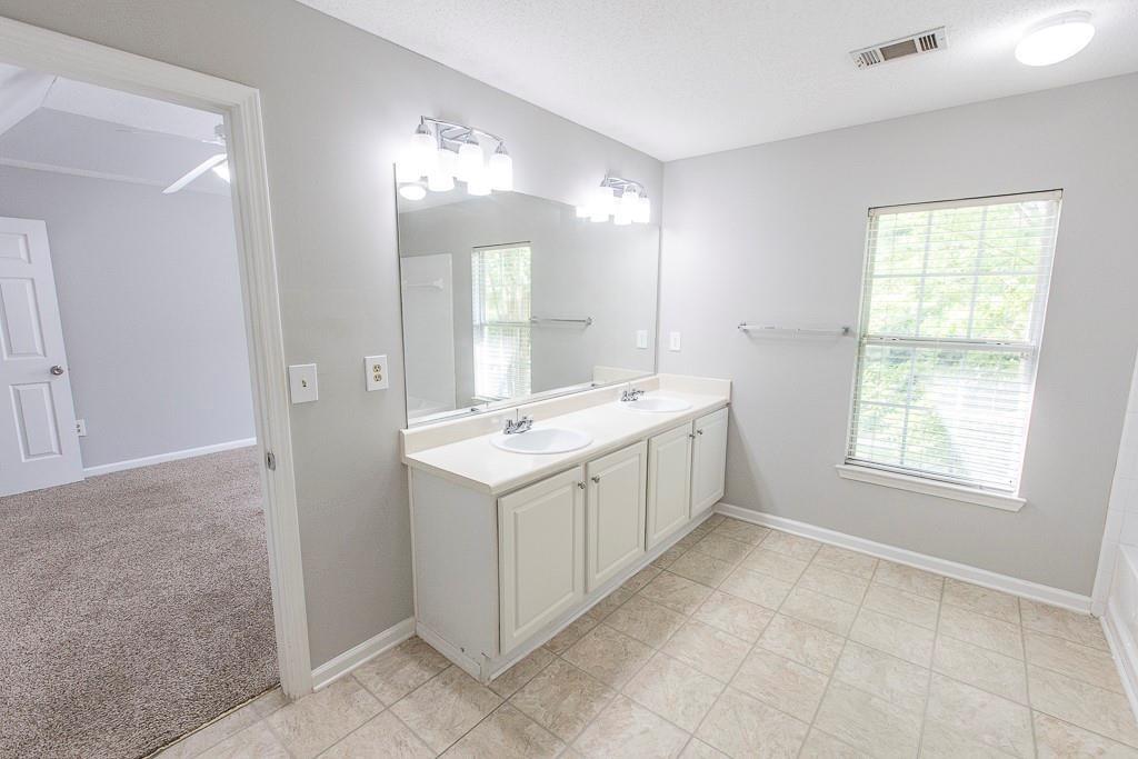1731 Pryor Road Southwest, Unit 109 Atlanta, GA 30315 - Photo 21 of 34 a view of a bathroom with double vanity sink a mirror and a shower