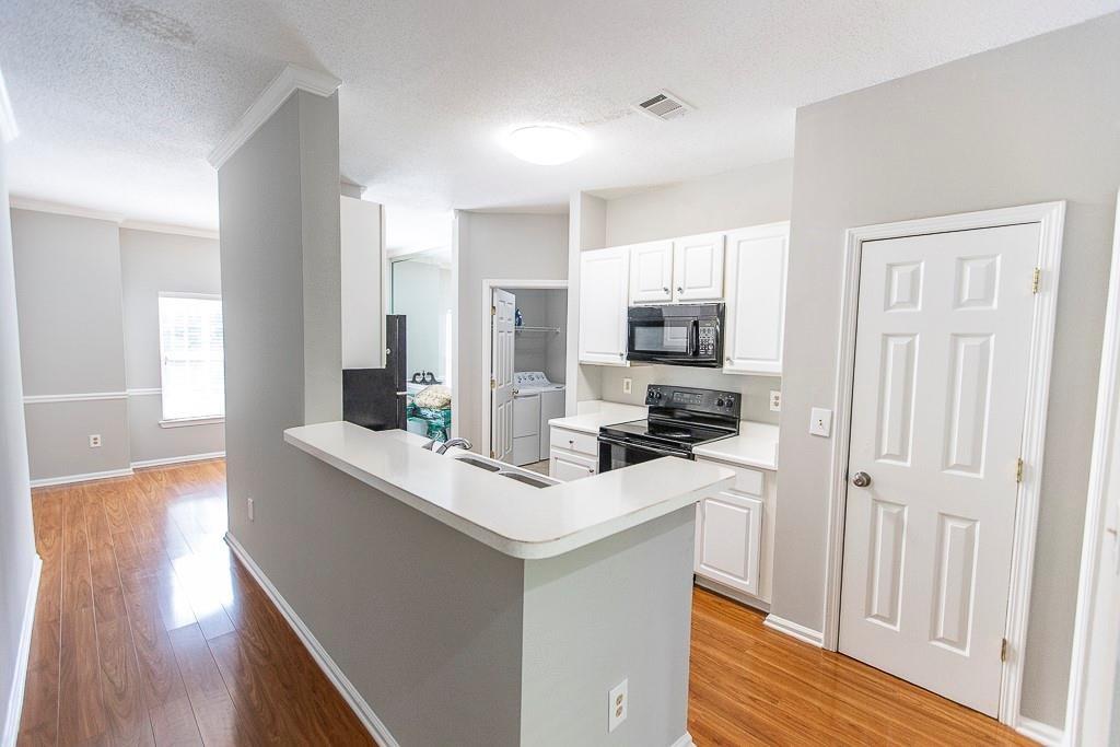 1731 Pryor Road Southwest, Unit 109 Atlanta, GA 30315 - Photo 4 of 34 a kitchen with a sink a stove a microwave and a refrigerator
