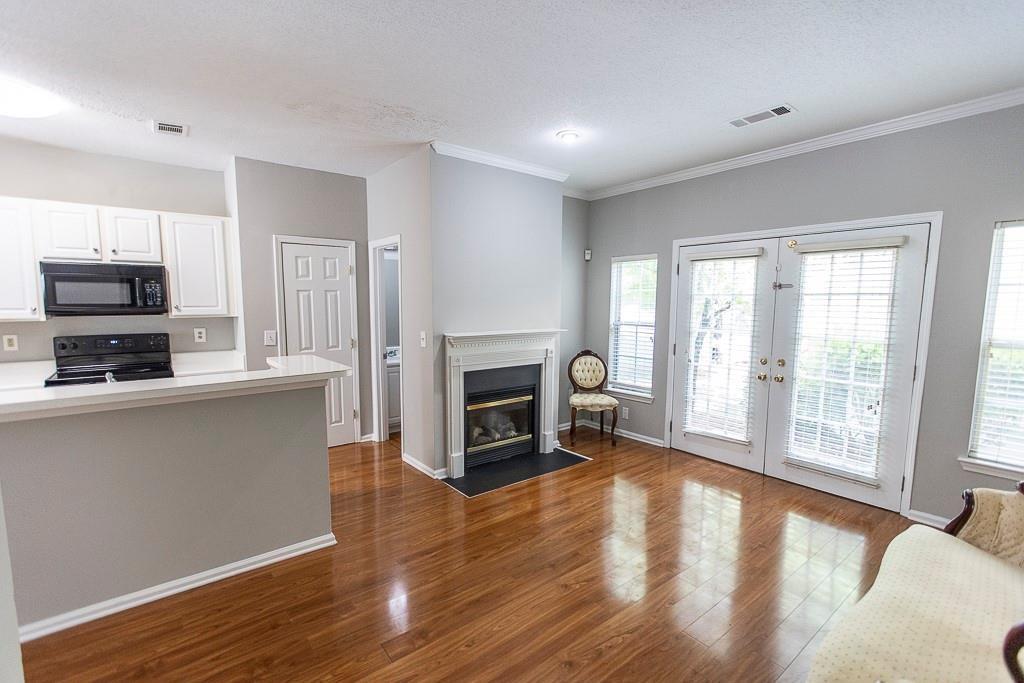 1731 Pryor Road Southwest, Unit 109 Atlanta, GA 30315 - Photo 10 of 34 a living room with stainless steel appliances a fireplace a flat screen tv and a large window