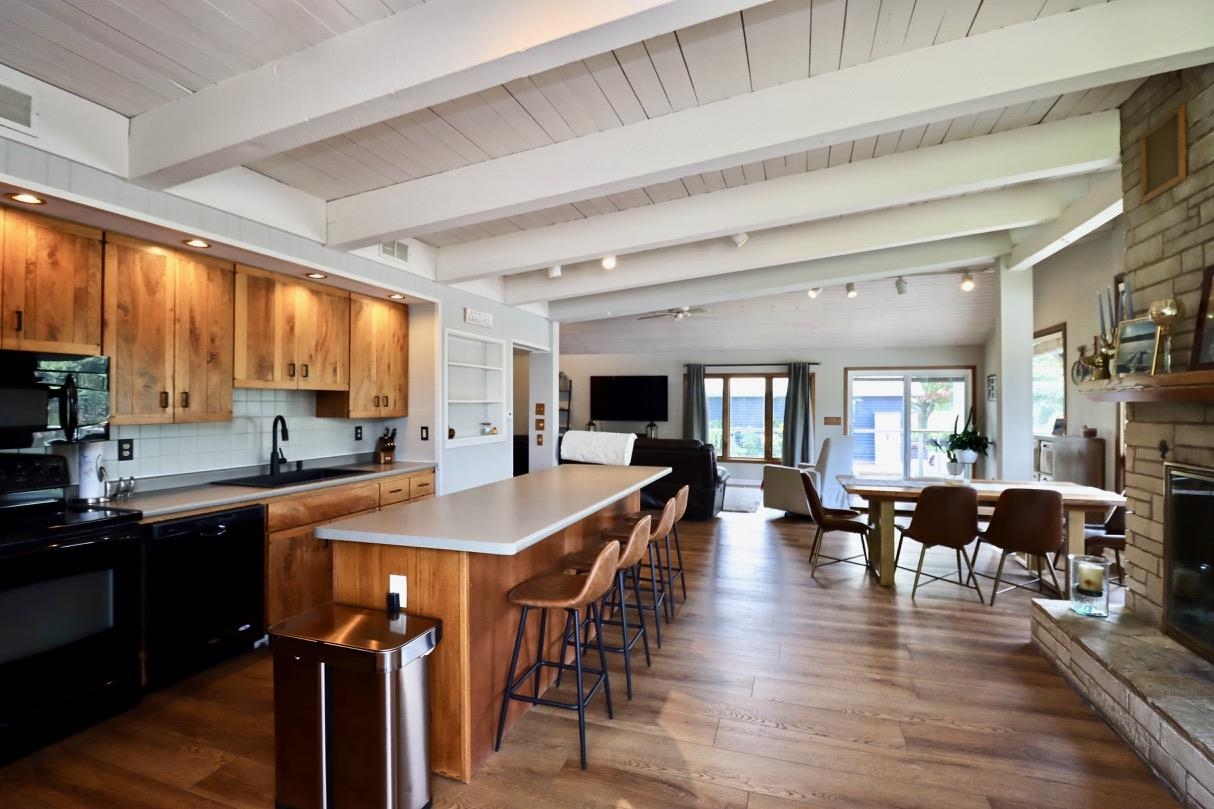 2870 South Riverside Drive Beloit, WI 53511 - Photo 19 of 32 a dining hall with stainless steel appliances granite countertop a stove a refrigerator a kitchen island a dining table and chairs with wooden floor