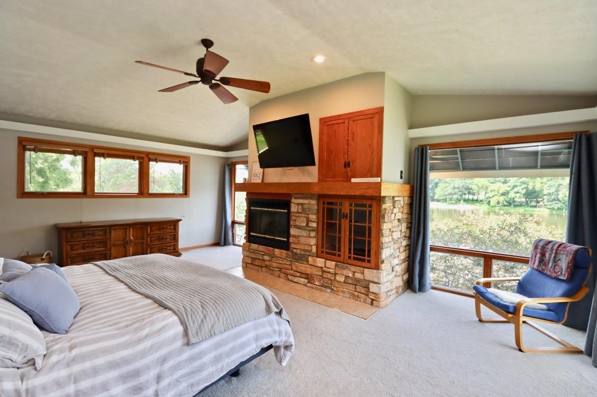 2870 South Riverside Drive Beloit, WI 53511 - Photo 6 of 32 a bedroom with a bed and a fireplace