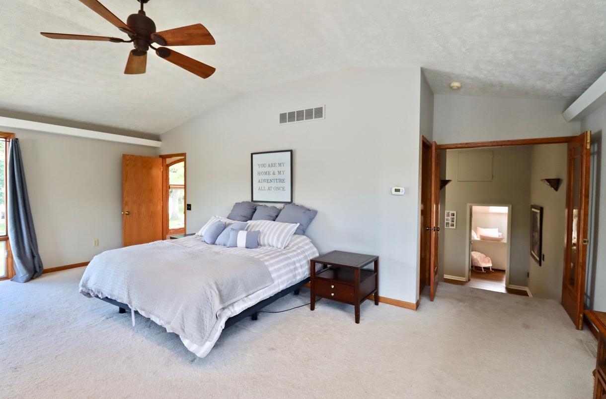 2870 South Riverside Drive Beloit, WI 53511 - Photo 9 of 32 a bedroom with a bed and a chandelier
