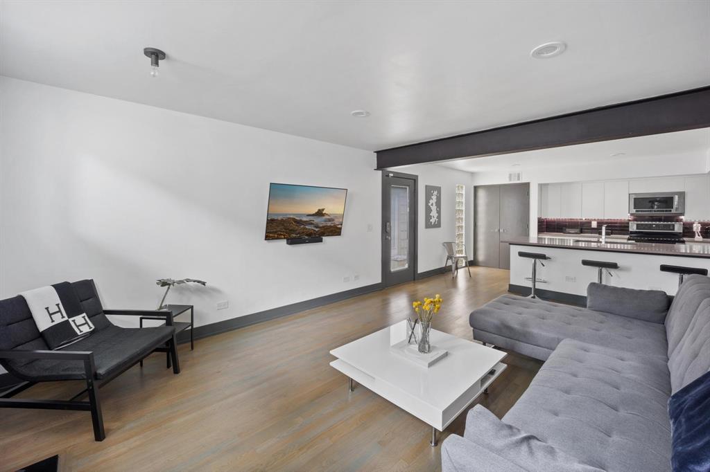 4134 Travis Street, Unit 11 Dallas, TX 75204 - Photo 11 of 29 a living room with furniture and a wooden floor