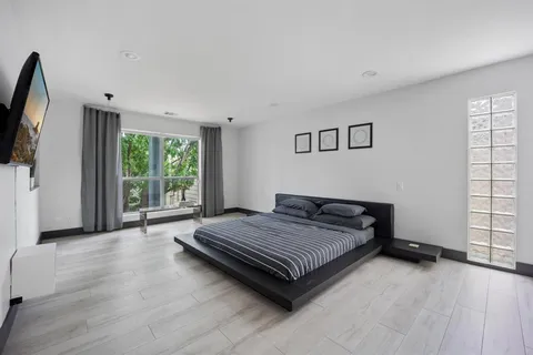 a spacious bedroom with a bed and wooden floor