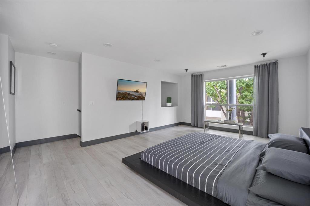 4134 Travis Street, Unit 11 Dallas, TX 75204 - Photo 20 of 29 a bedroom with a large bed and a window