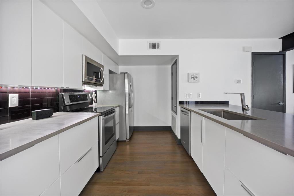 4134 Travis Street, Unit 11 Dallas, TX 75204 - Photo 8 of 29 a kitchen with a sink and stainless steel appliances