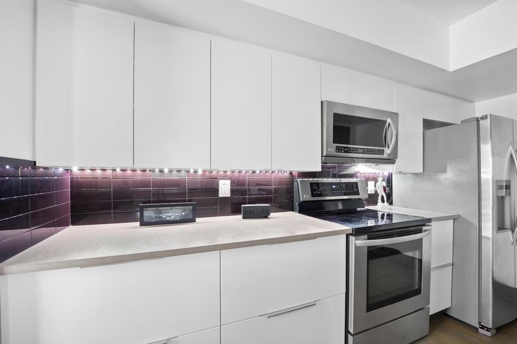 4134 Travis Street, Unit 11 Dallas, TX 75204 - Photo 9 of 29 a kitchen with stainless steel appliances a stove microwave and refrigerator