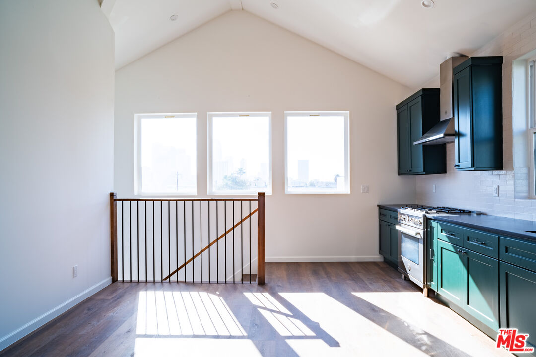 a view of a kitchen with a sink window and wooden floor