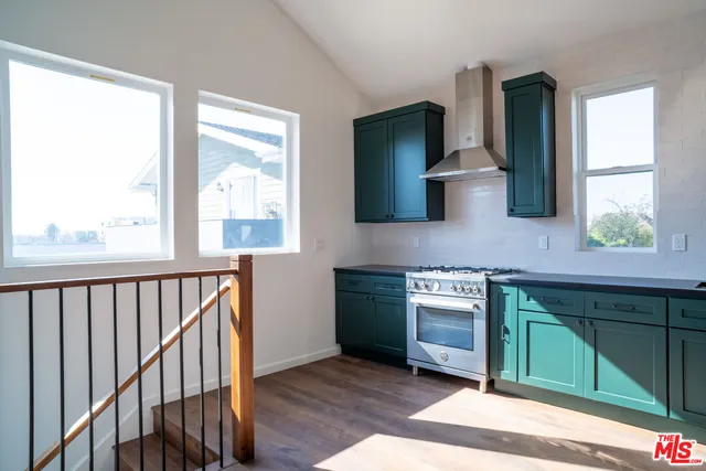 a kitchen with stainless steel appliances granite countertop a stove a sink and a window