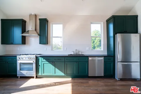 a kitchen with stainless steel appliances granite countertop a refrigerator and a sink