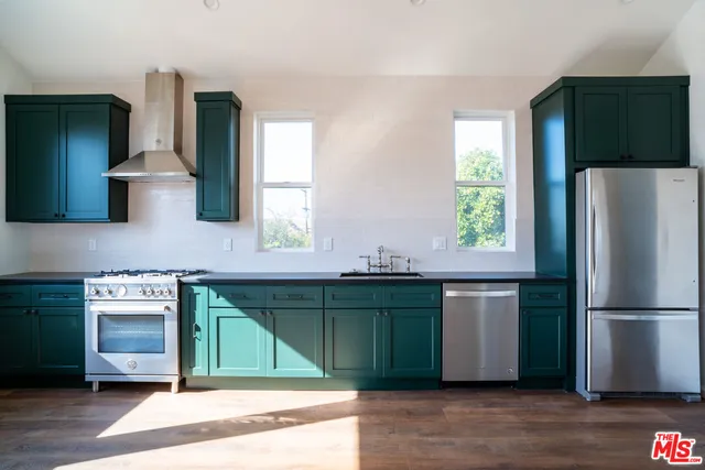 a kitchen with stainless steel appliances granite countertop a refrigerator and a sink