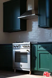 a stove top oven sitting inside of a kitchen